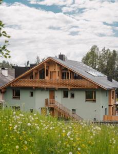 una casa con tetto in legno in un campo di Max Green Forest Apartments a Siusi