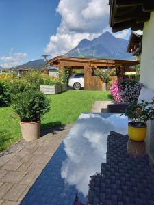 ein Haus mit einem Spiegelbild des Himmels in einem Hof in der Unterkunft Appartements Lederer in Maria Alm am Steinernen Meer