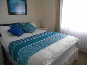 - une chambre avec un lit doté d'oreillers bleus et d'une fenêtre dans l'établissement Blue Line Retreat - Unit 1, à Port Vincent