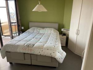 een slaapkamer met een bed en een groene muur bij Bristol Palace Seaview 7e verdieping, 30 meter van strand in Blankenberge