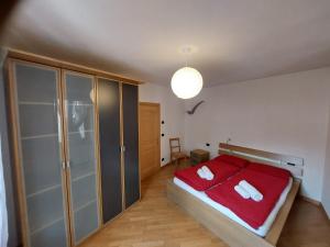 1 dormitorio con cama roja y armario de cristal en Appartamento Borgo Centro, en Borgo