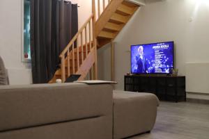 ein Wohnzimmer mit Couch und Flachbildfernseher in der Unterkunft Pavillon en loft 87 M 10e, jacuzzi in Marseille