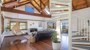 a living room with a staircase in a house at The Point Ultimate Beach House in Yamba