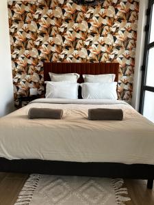 ein Schlafzimmer mit einem großen Bett mit einer Wand in der Unterkunft Studio - Le Clos du fond cailloux in Longuenesse