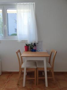 une table en bois avec des chaises et une fenêtre dans l'établissement Magnifique Studio à louer, à Evilard