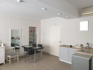 a kitchen with white cabinets and a table and chairs at CAMELLIA STUDIO apartment & parking in Rīga