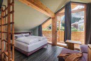 a bedroom with a bed and a large window at Max Green Forest Apartments in Siusi