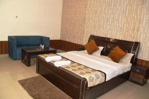 a bedroom with a bed with a chair and a table at Hotel Udika Palace in Kaohni +17 photos