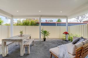 eine Terrasse mit einem Holztisch und einem Sofa in der Unterkunft Stylish family home, centrally located. in Thirlmere