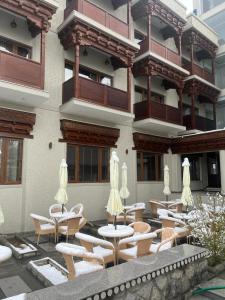 een gebouw met een patio met tafels en stoelen bij Ashoka Ladakh in Leh