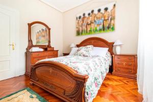 - une chambre avec un lit, deux commodes et un miroir dans l'établissement Apartamento Centro de Santander, à Santander