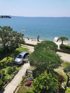 a car parked in a park next to the ocean at Villa Katarina in Petrcane