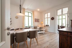 eine Küche und ein Wohnzimmer mit einem Tisch und Stühlen in der Unterkunft Villa Frohsinn - Appartement 09 in Bansin