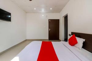 a bedroom with a bed with red pillows on it at OYO Flagship 80902 Swagat Hotel in Bhiwadi