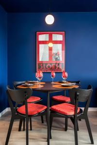 a dining room with a black table and red chairs at Kairos Apartments - Gwarek - darmowy parking, ścisłe centrum in Katowice