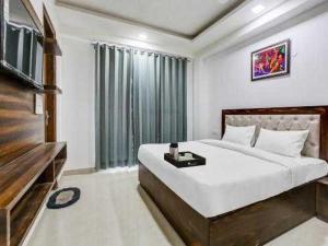 - une chambre avec un grand lit et une télévision à écran plat dans l'établissement OYO 81358 Hotel Green Star, à Moradabad