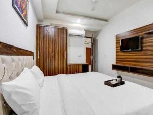 - une chambre avec un grand lit blanc et une télévision dans l'établissement OYO 81358 Hotel Green Star, à Moradabad