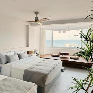 a bedroom with a large bed and a view of the ocean at Stay Saeroc in Geoje 