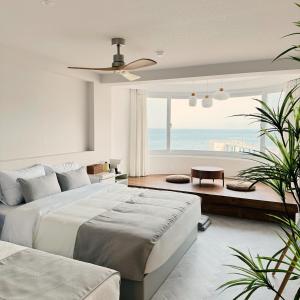 a bedroom with a large bed and a view of the ocean at Stay Saeroc in Geoje