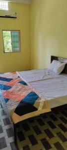 een slaapkamer met een bed met een kleurrijke quilt bij OYO Hotel Daisy in Jabalpur