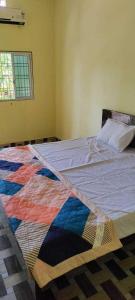 een slaapkamer met een bed met een kleurrijke quilt bij OYO Hotel Daisy in Jabalpur