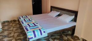 een bed met een houten hoofdeinde en 2 kussens bij OYO Hotel Daisy in Jabalpur