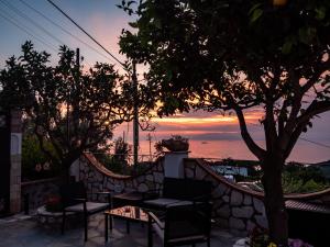 a patio with a table and chairs and a sunset at Casa Astra in Anacapri