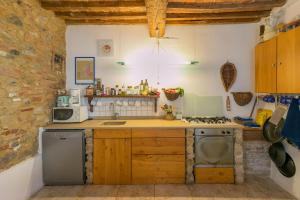 eine Küche mit einer Spüle und einem Herd Top-Backofen in der Unterkunft La Stallina in Sant'Ermo