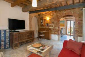 ein Wohnzimmer mit einem roten Sofa und einem TV in der Unterkunft La Stallina in Sant'Ermo