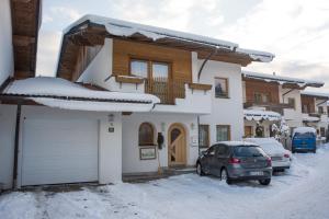 ein Haus mit einem Auto im Schnee in der Unterkunft Ferienhaus Siglinde in Söll