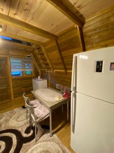 eine Küche mit einem Tisch und einem Kühlschrank im Zimmer in der Unterkunft Şehre yakın doğa içinde Bungalov 