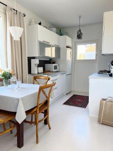 cocina y comedor con mesa y sillas en Cozy apartment with free parking en Espoo