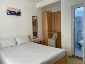 a bedroom with a bed and a bathroom with a toilet at Casa Double M in Vama Veche