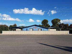 a blue building with a fence in front of a street at Blue Line Retreat - Unit 3 in Port Vincent +12 photos