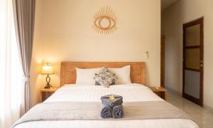 a bedroom with a large bed with a wooden headboard at Townhouse, Pool & Kitchen, Ubud, Cucus Mondok in Ubud