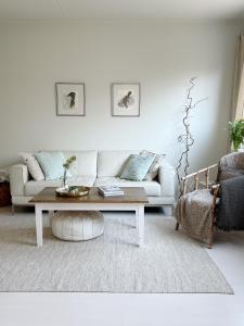 a living room with a white couch and a coffee table at Cozy apartment with free parking in Espoo