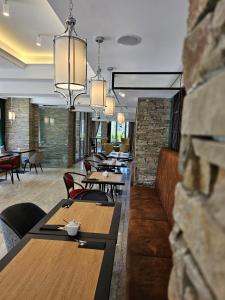 ein Restaurant mit Holztischen, Stühlen und Kronleuchtern in der Unterkunft Rysy Boutique Hotel in Zakopane