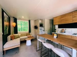 eine Küche und ein Wohnzimmer mit einem Sofa und einem Tisch in der Unterkunft Chalet Teifëlslee in Goebelsmuhle