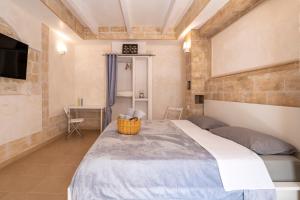 a bedroom with a large bed and a television at Â Chése De Menòple in Monopoli