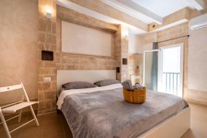 Un dormitorio con una cama y una silla y una ventana. en Â Chése De Menòple by STHEY, en Monopoli