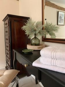 a bedroom with a desk with a mirror and towels at The Byre, at Cradle Barn offering a king suite in Abingdon +7 photos