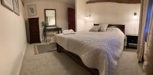 a bedroom with a large bed and a desk at The Byre in Abingdon