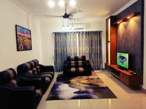 a living room with couches and a flat screen tv at EZHomestay Platinum near Cyberjaya Putrajaya KLIA in Kampung Dengkil