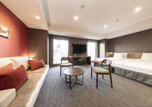 Habitación de hotel con 2 camas y sofá en Tokyu Stay Sapporo en Sapporo