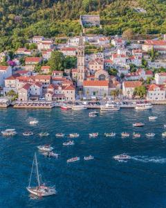 a group of boats in the water near a city at Conte Hotel & Restaurant in Perast