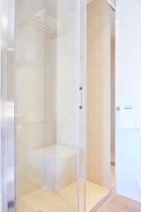 La salle de bains est pourvue d'une douche avec une porte en verre. dans l'établissement Hostal Gami Adults Only, à Cala Ratjada