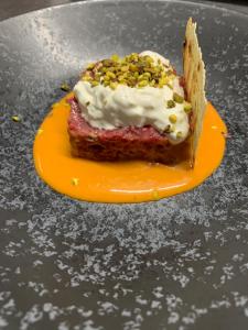 un trozo de pastel en un plato naranja en una mesa en Hotel Ristorante Cibarium, en Gualdo Tadino