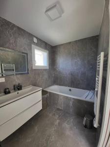 a bathroom with a tub and a sink at Nice, Magnifique villa vue mer avec piscine in Nice