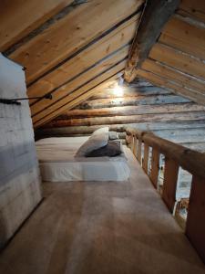 a bed in an attic with a wooden ceiling at Villa Lavijoki in Karesuvanto