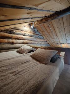 a bed in a room with a wooden ceiling at Villa Lavijoki in Karesuvanto